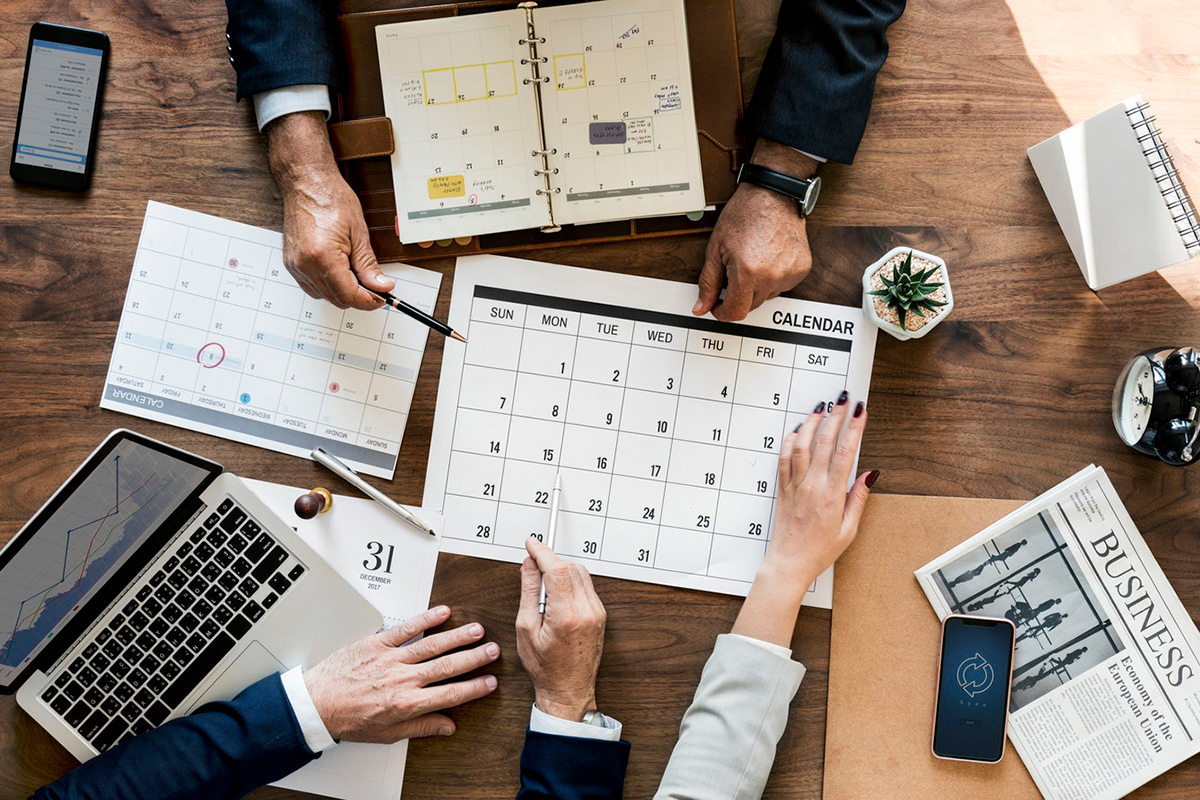 Business meeting with calendar, laptop and phone.