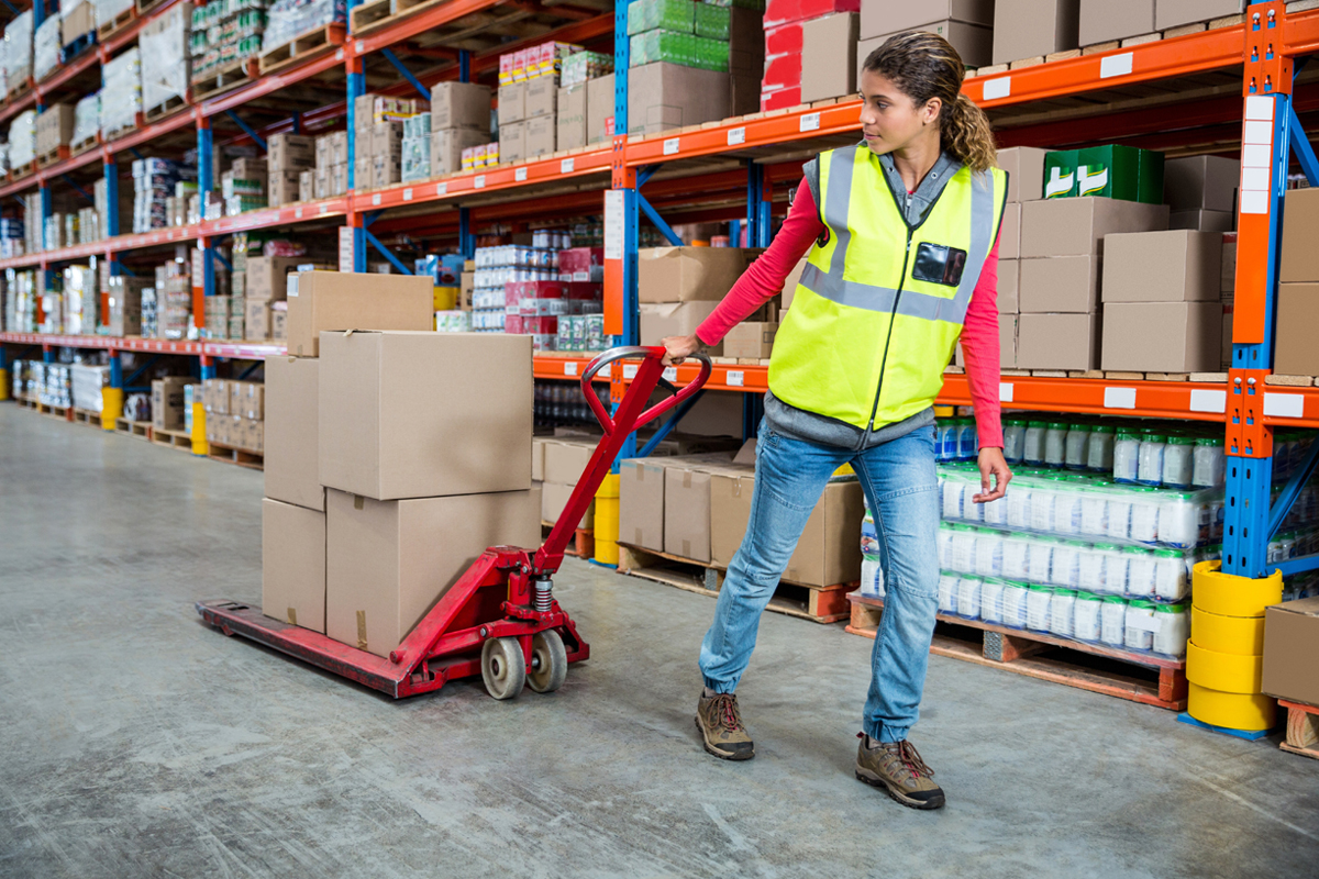 Warehouse with man putting trolley with boxes.